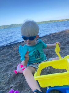 bambino albino in spiaggia con occhiali scuri